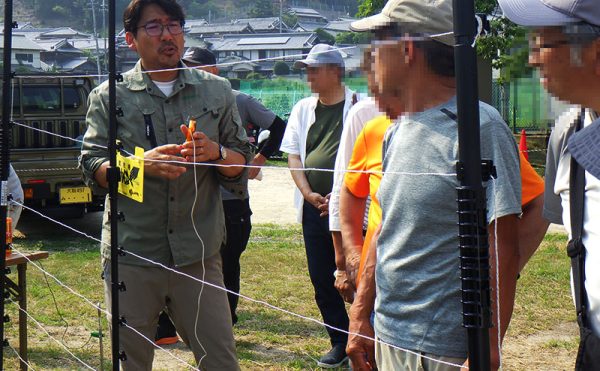 画像：屋外に設置した電気柵について解説する様子①